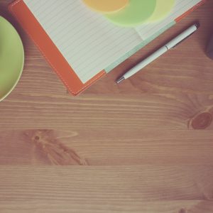 爱给编辑林知白的检索工作照：深色桌面上一台笔记本与便签墙，人物侧脸对着屏幕比对来源，暖色台灯照亮手边笔记